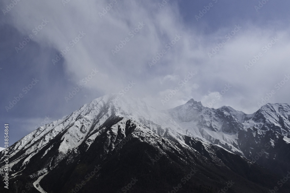 Obraz premium Himalaya - Snowy, Dark, Dramatic Mountain Peaks Dusted in Soft Clouds