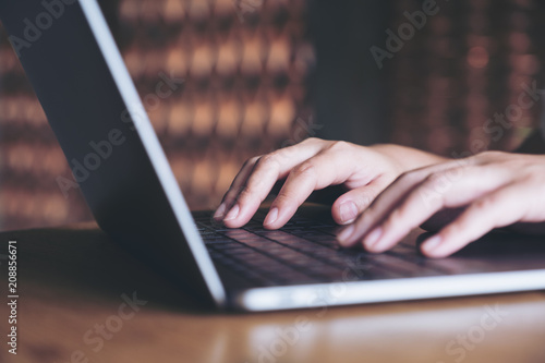 Closeup image of hands working and typing on laptop keyboard in office