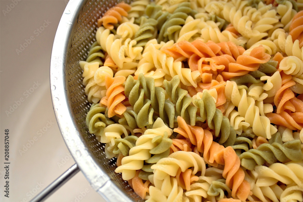 Fusilli (Fuso) - classic Italian pasta in the form of a spiral of durum wheat. Ingredient for cooking a traditional Italian dish. Cooking process. Soft focus, close-up. A place to copy. Fusilli (Fuso) - classic Italian pasta in the form of a spiral of durum wheat. Ingredient for cooking a traditional Italian dish. Cooking process. Soft focus, close-up. A place to copy.