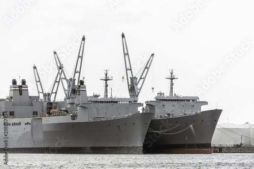two military transport ships of gray color are in port
