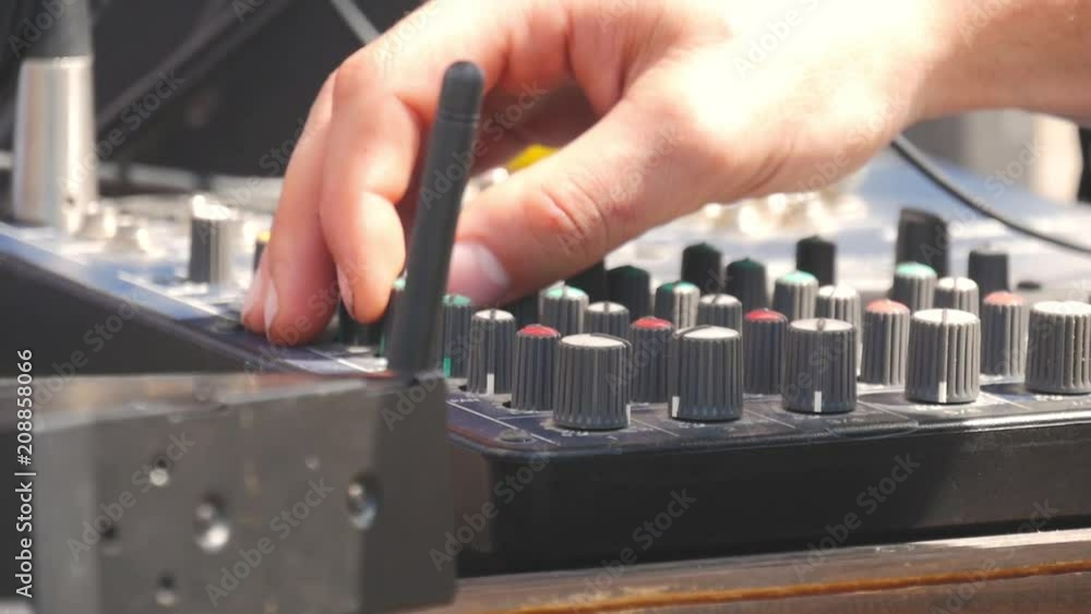 Man working on professional digital audio channel mixer. Electronics for amplifier and balance of sound in show. Soundboard knobs. sound engineer presses the keys, moves the buttons. Man working on professional digital audio channel mixer. Electronics for amplifier and balance of sound in show. Soundboard knobs. sound engineer presses the keys, moves the buttons.