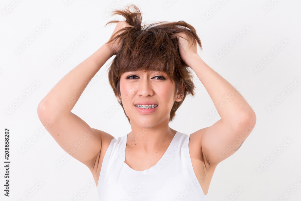 Health and pain. Stressed exhausted young woman having strong tension headache. Isolated on white background. Studio lighting. Concept for healthy and medical Health and pain. Stressed exhausted young woman having strong tension headache. Isolated on white background. Studio lighting. Concept for healthy and medical