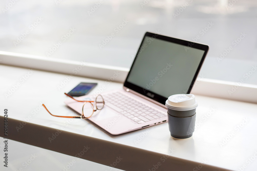 Desk with laptop, eye glasses, and a cup of coffee. Concept of business Desk with laptop, eye glasses, and a cup of coffee. Concept of business