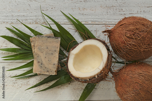 coconut soap.soap with coconut extract. Handmade soap with coconut oil on a palm leaf and fresh coconut in a cut on a shabby wooden background. Organic Natural Cosmetics