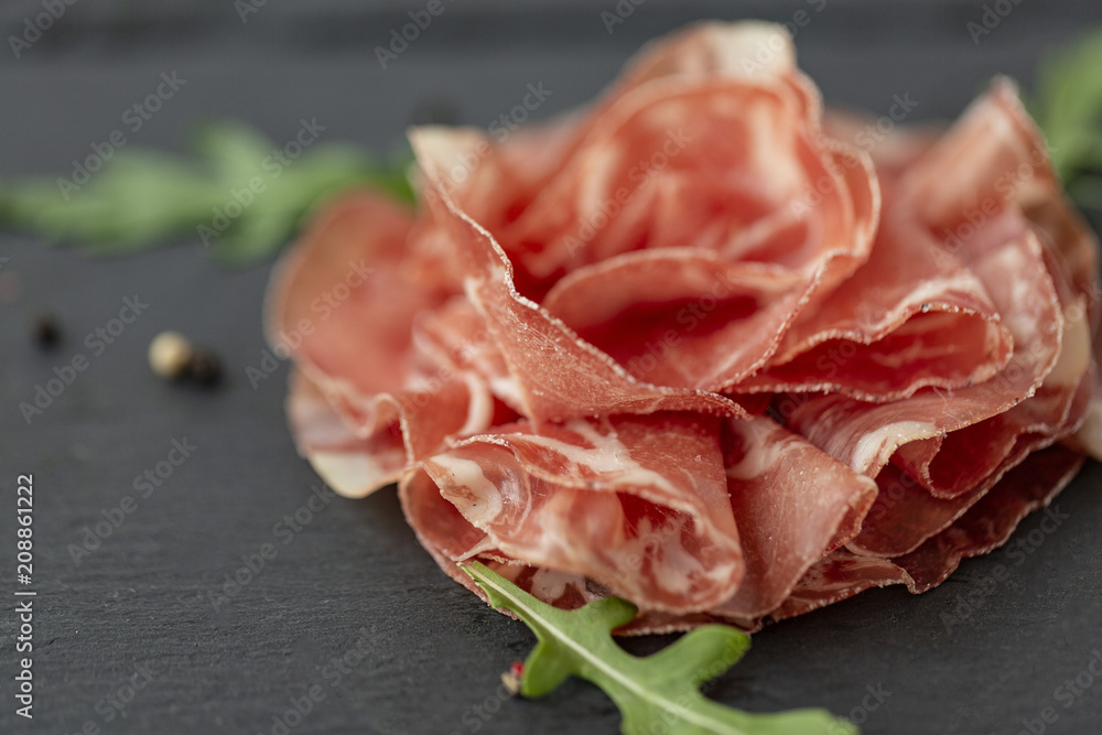 Italian prosciutto or jamon with arugula. Raw ham. Top view