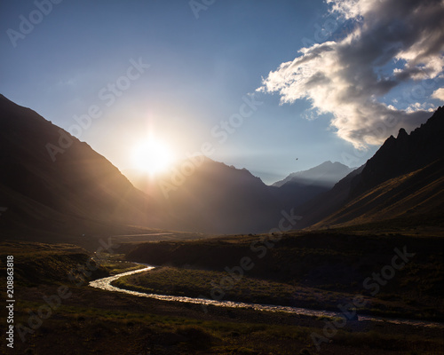 Mountain sunset with snaking river, blue sky and clouds