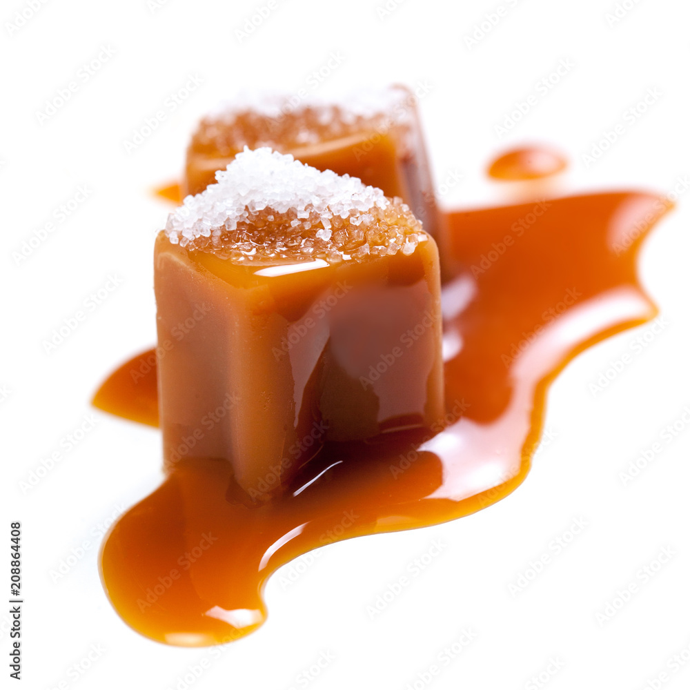 Salt Caramel candies with liquid sauce isolated on white background
