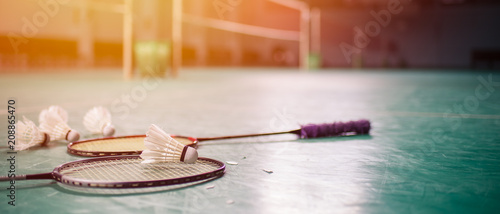 Badminton ball (shuttlecock) and racket on court floor