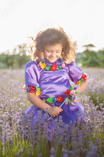 happy adorable caucasian little girl in fairy purple dress and magic stick