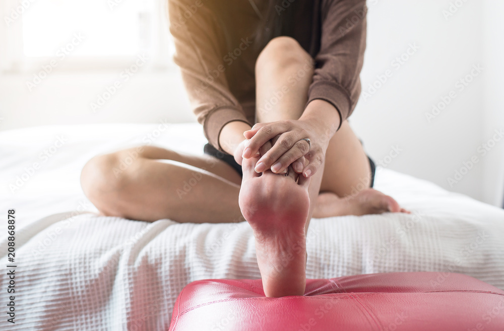 Woman hands giving massage to her foots in bedroom,foot soles massage