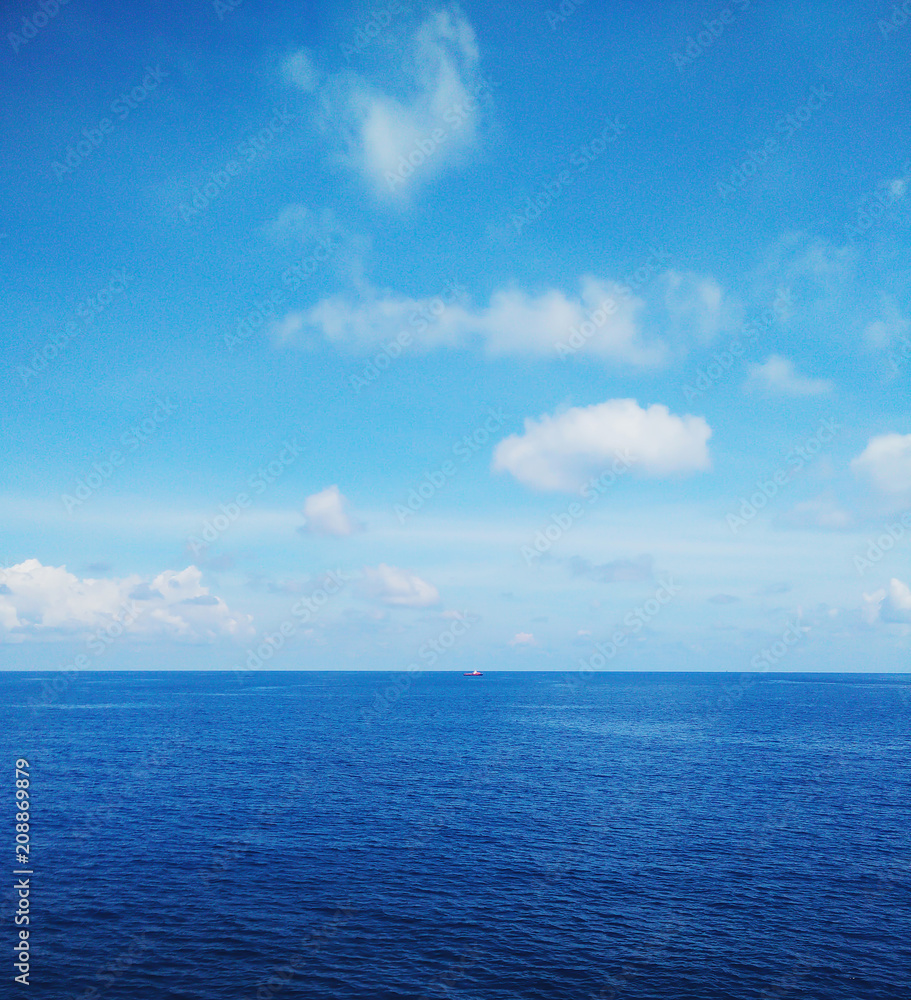 Obraz premium White fluffy clouds in the blue sky,breezy,Fresh on all day.Seeing a small boat.