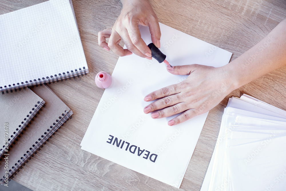 No matter what. Close up of smooth female hands lying on paper with deadline and using nail polish No matter what. Close up of smooth female hands lying on paper with deadline and using nail polish