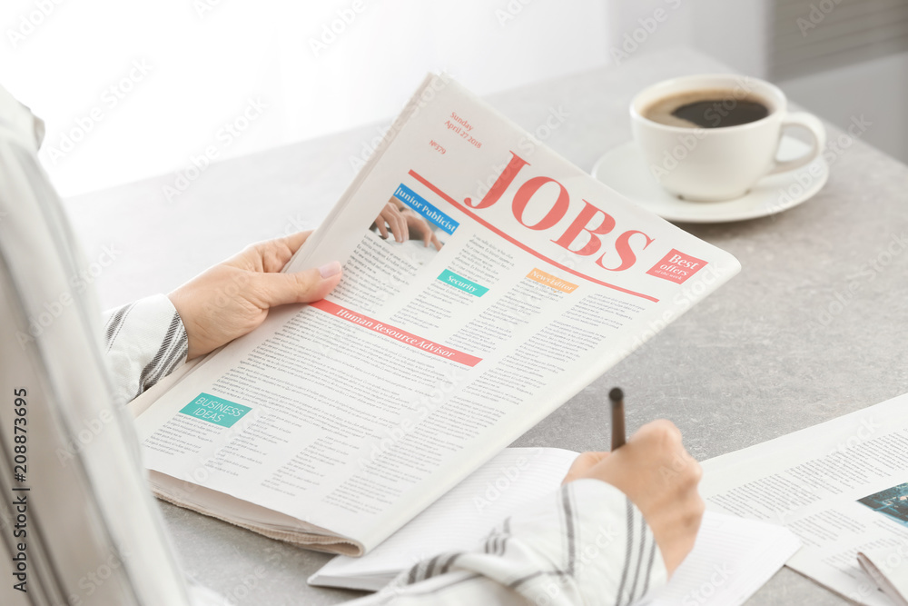 Woman reading morning newspaper indoors Woman reading morning newspaper indoors