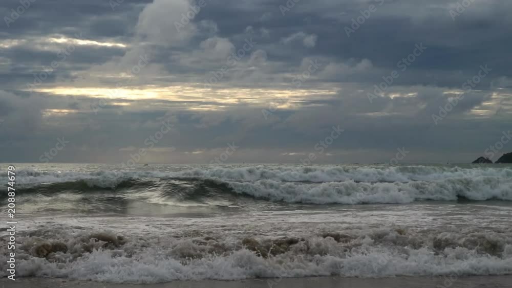 sandy beach with waves at sunset, thunderclouds on a sky. dramatic atmosphere sandy beach with waves at sunset, thunderclouds on a sky. dramatic atmosphere