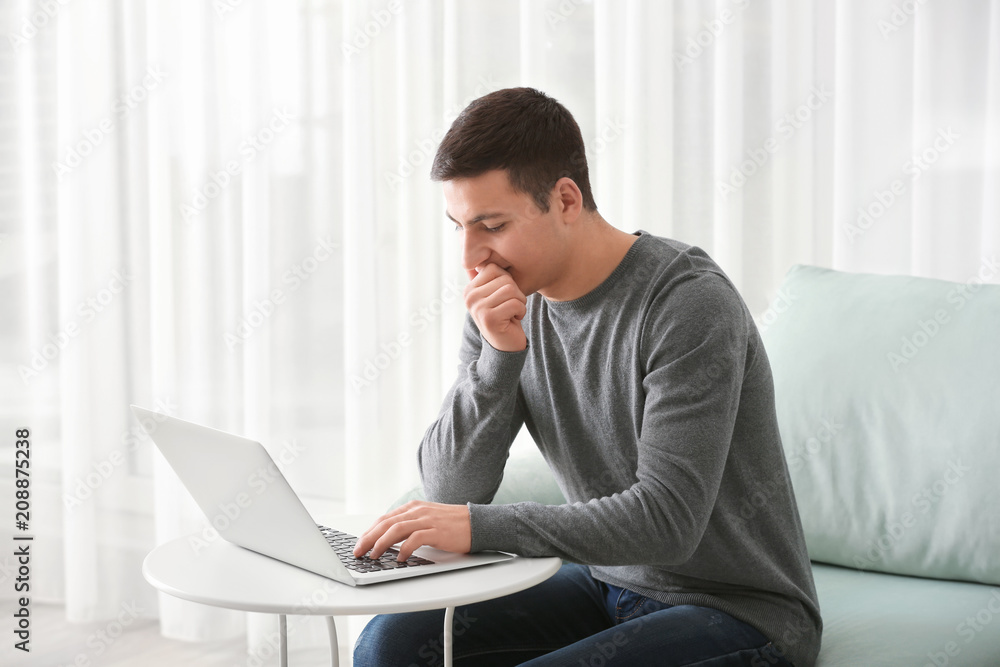 Young man working with laptop at home Young man working with laptop at home