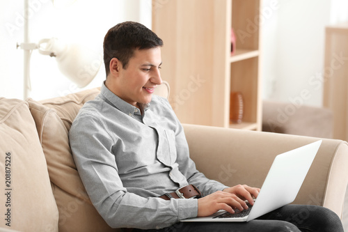 Young man working with laptop at home