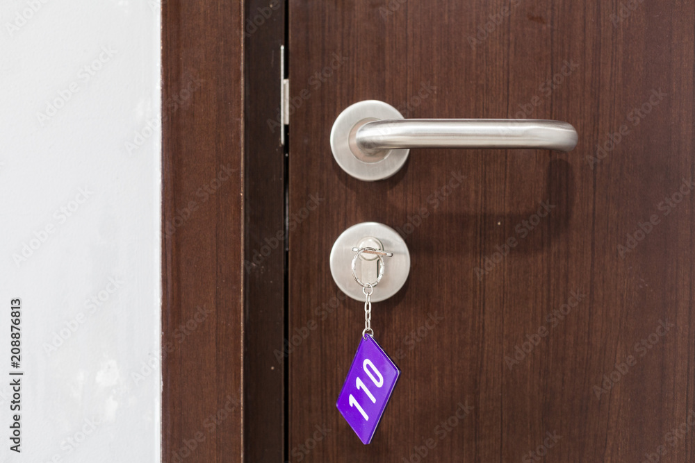 Obraz premium Door of hotel room with key in the lock