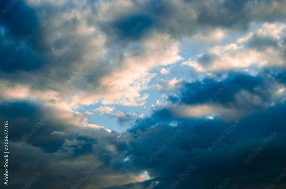 Storm clouds against a bright blue sky.