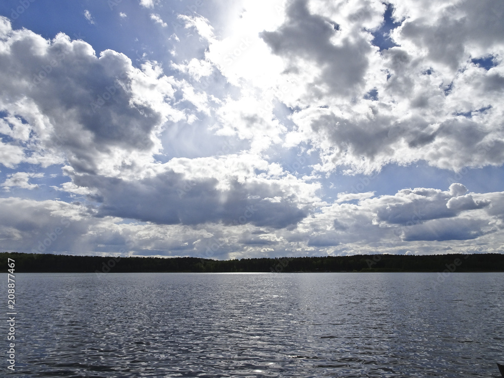 Summer landscape: blue lake on a Sunny day and sky with feathery clouds