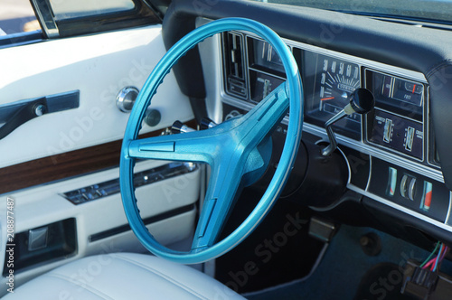 Fragment retro car dashboard. White leather and blue steering wheel.