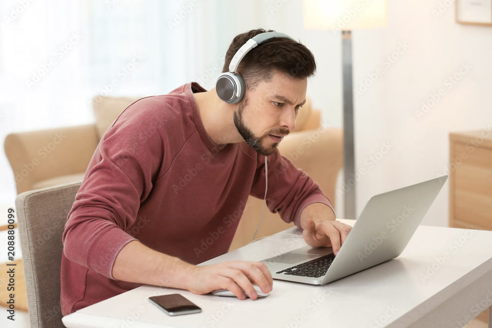Emotional man playing computer game at home Emotional man playing computer game at home