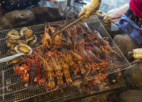 Fresh Abalones and Japanese spiny lobsters being charcoal grilled in traditional Japanese style in Mie , Japan