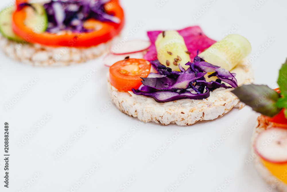 Open sandwiches of rice cakes with cream cheese , vegetables