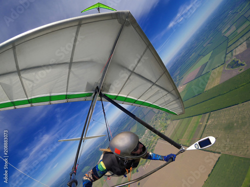Hang glider pilot soar the thermal updrafts high over terrain
