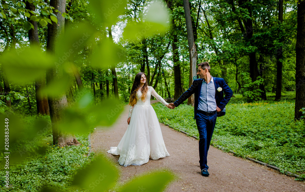 A stunning couple walks in the path of the park A stunning couple walks in the path of the park