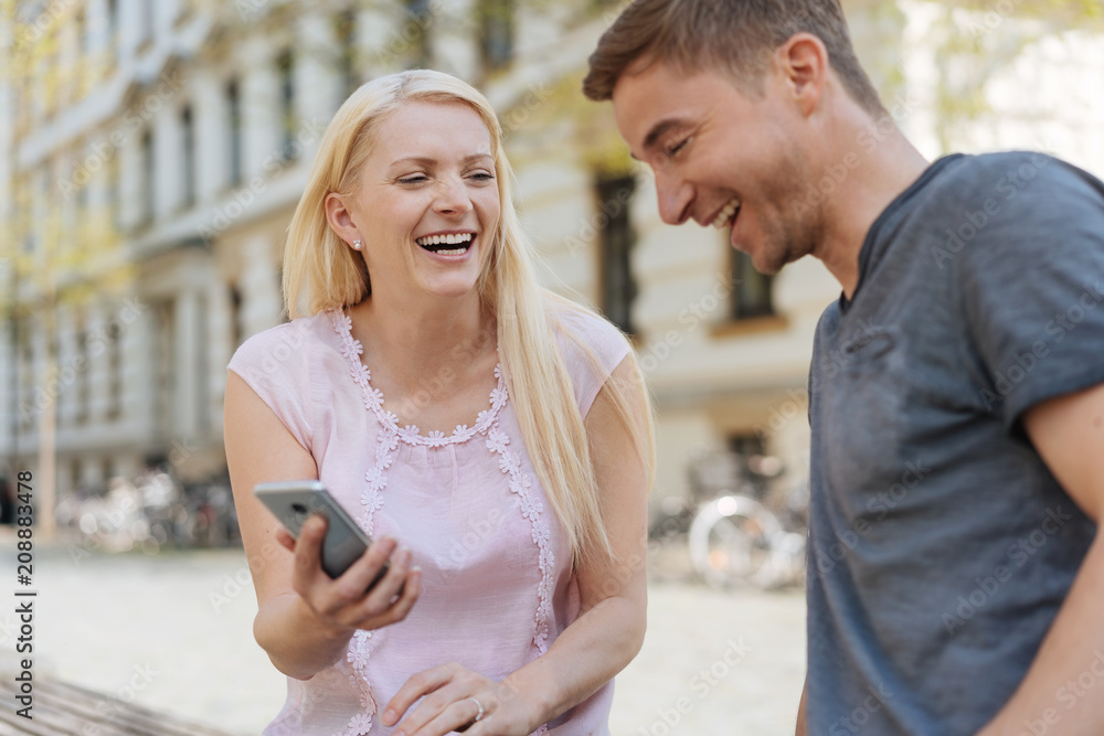 Laughing couple looking at data on a mobile Laughing couple looking at data on a mobile