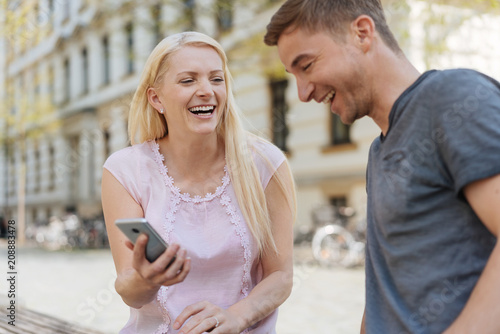 Laughing couple looking at data on a mobile