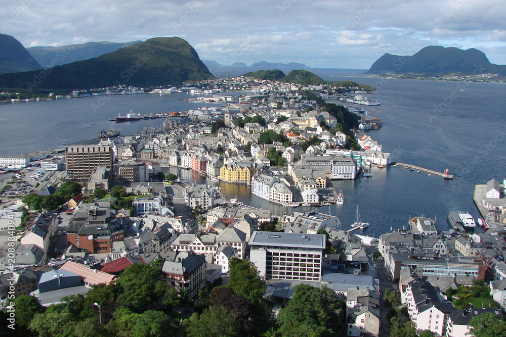 The landscape of the Norwegian town of Alesund under the sun's rays against the background of the bay.