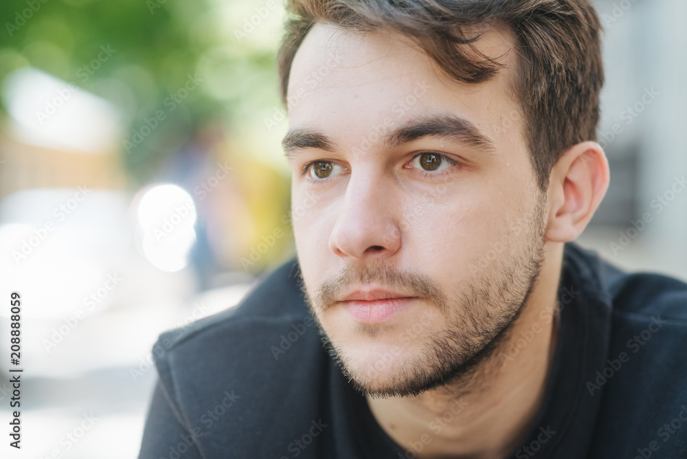 Obraz premium An attractive and handsome man with stylish hair and beard, interesting funny story. Portrait of a worried young man at the workplace. Stress concept.
