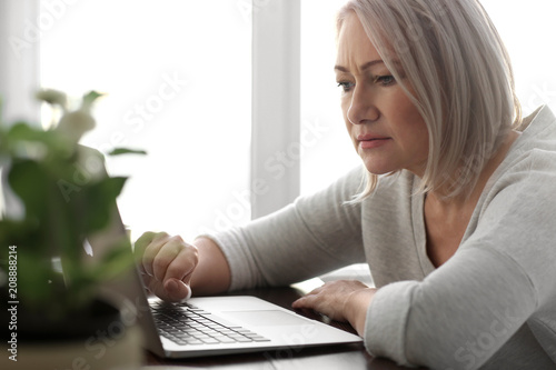Mature woman reading news o...