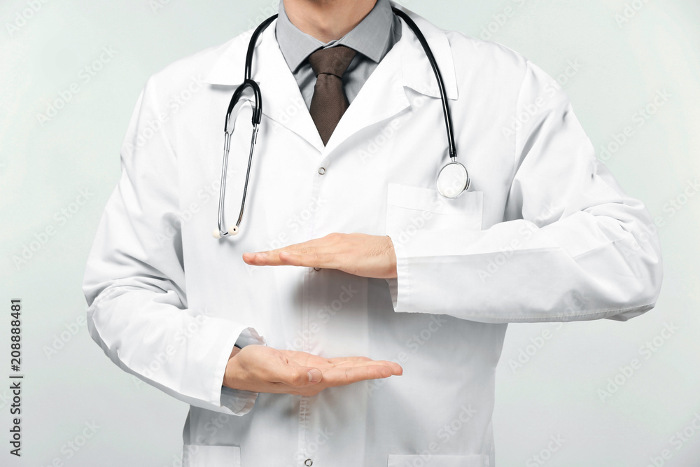 Male doctor holding something on white background Male doctor holding something on white background