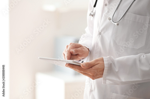 Male doctor with tablet PC in office