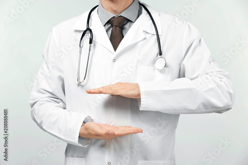 Male doctor holding something on white background