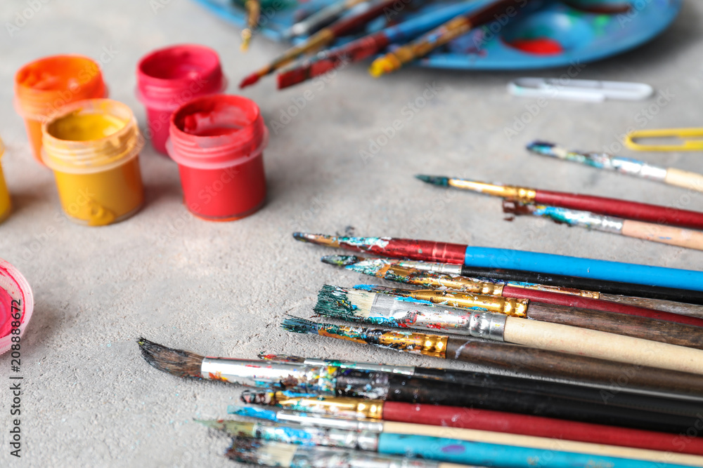 Obraz premium Brushes and jars with paints on table