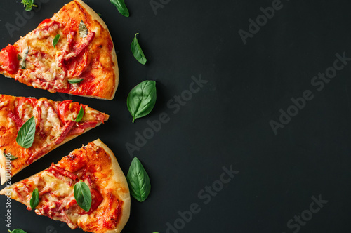 Three slices salami mozarella pizza black background. Top view f