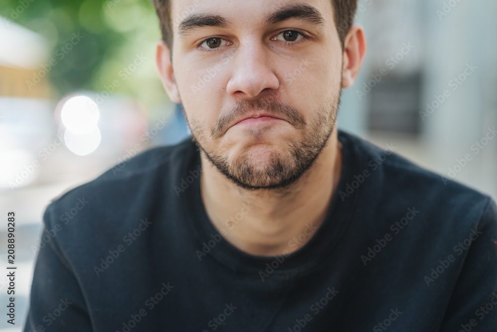 A young handsome man was surprised and bit his lip. Live emotions, space for text A young handsome man was surprised and bit his lip. Live emotions, space for text