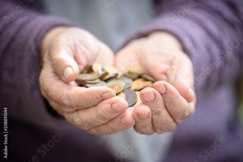 Money, coins, the grandmother on pension and the concept of life, minimum - in hands old a handful of coins. Close up
