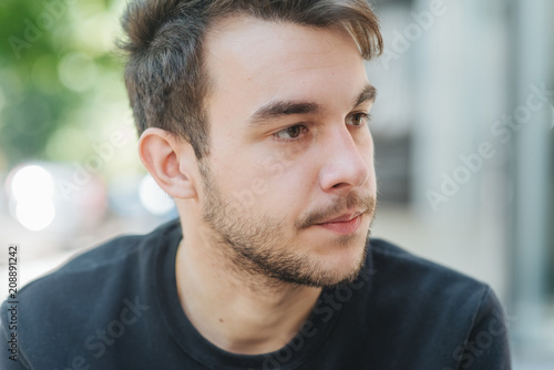 Close up portrait of a American man Confident and successful. Handsome young man looking away outdoors with city in the background