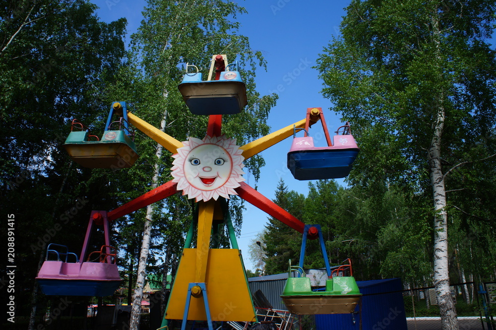 children's ferris wheel on a forest in the park children's ferris wheel on a forest in the park