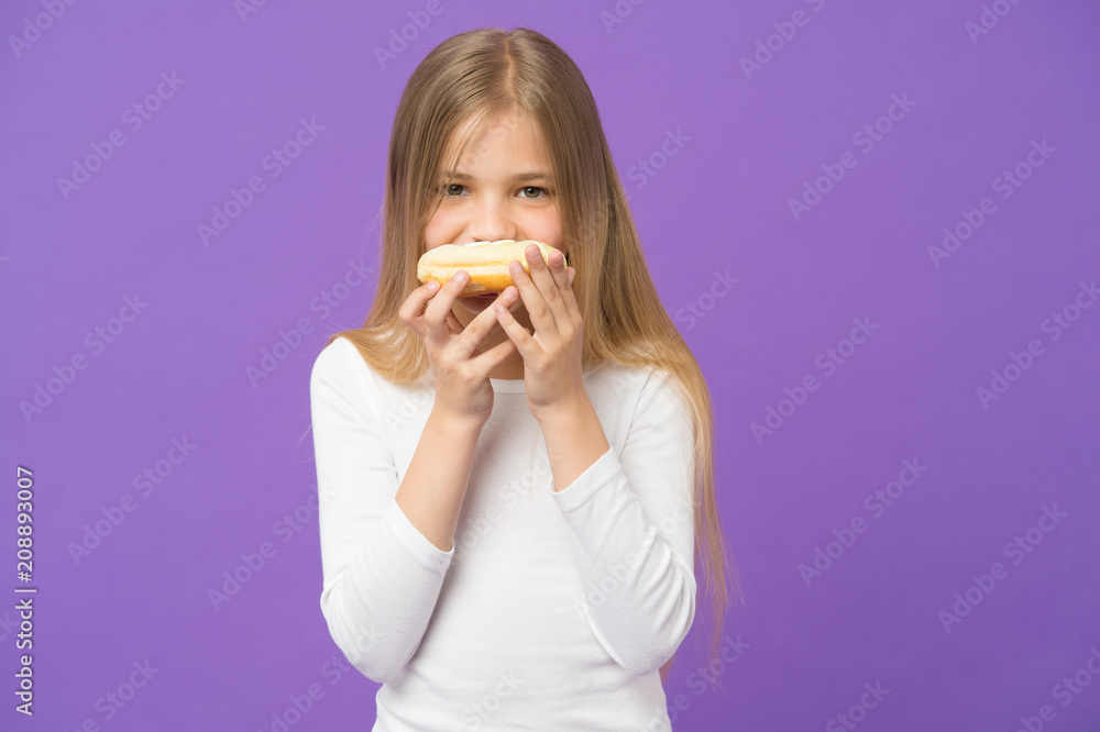Having snacks. Child eat donut on violet background. Little girl with glazed ring doughnut on purple background. Kid with junk food. Food for snack and dessert. Childhood and childcare, copy space Having snacks. Child eat donut on violet background. Little girl with glazed ring doughnut on purple background. Kid with junk food. Food for snack and dessert. Childhood and childcare, copy space