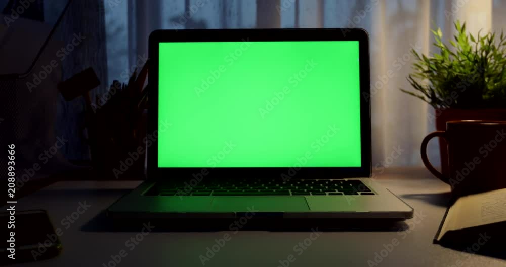 Laptop with green screen. Dark office. Dolly in. Perfect to put your own image or video.Green screen of technology being used. Chroma Key laptop Laptop with green screen. Dark office. Dolly in. Perfect to put your own image or video.Green screen of technology being used. Chroma Key laptop