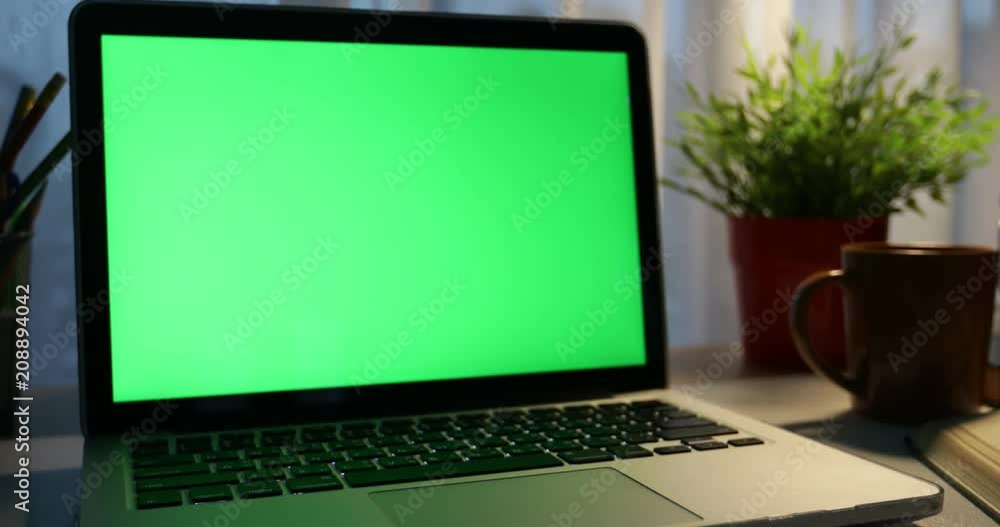 Laptop with green screen. Dark office. Dolly in . Perfect to put your own image or video.Green screen of technology being used. Chroma Key laptop Laptop with green screen. Dark office. Dolly in . Perfect to put your own image or video.Green screen of technology being used. Chroma Key laptop