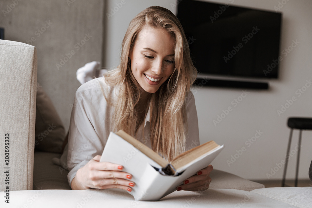 Smiling young woman reading blank cover open book Smiling young woman reading blank cover open book