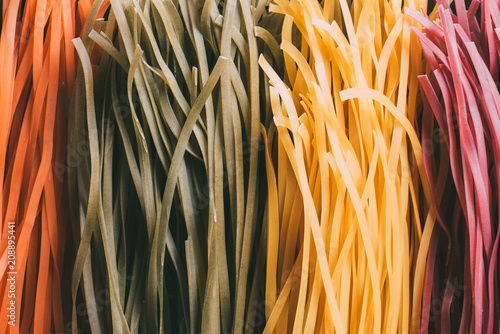 full frame image of arranged colorful raw tagliatelle pasta