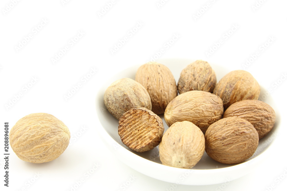 nutmeg seeds in a small white bowl nutmeg seeds in a small white bowl