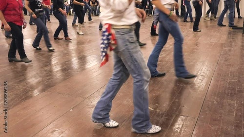 Country-dance at line dance celebration. Denim jeans, cowboy boots and USA flag. Dancers feet tapping and dancing on wooden ranch background.  Hoedown festival bluegrass music and tradition of America